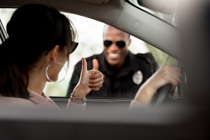 woman and cop giving thumbs up