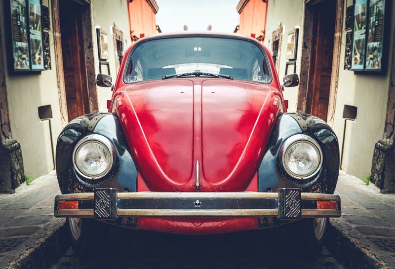 red classic car on narrow street