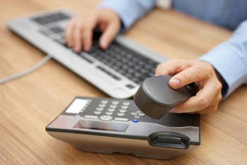 man picking up desk phone