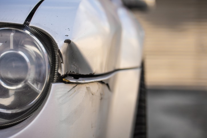 dent next to drivers side headlight on silver car